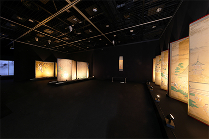 The artworks are displayed as if emerging from the darkness