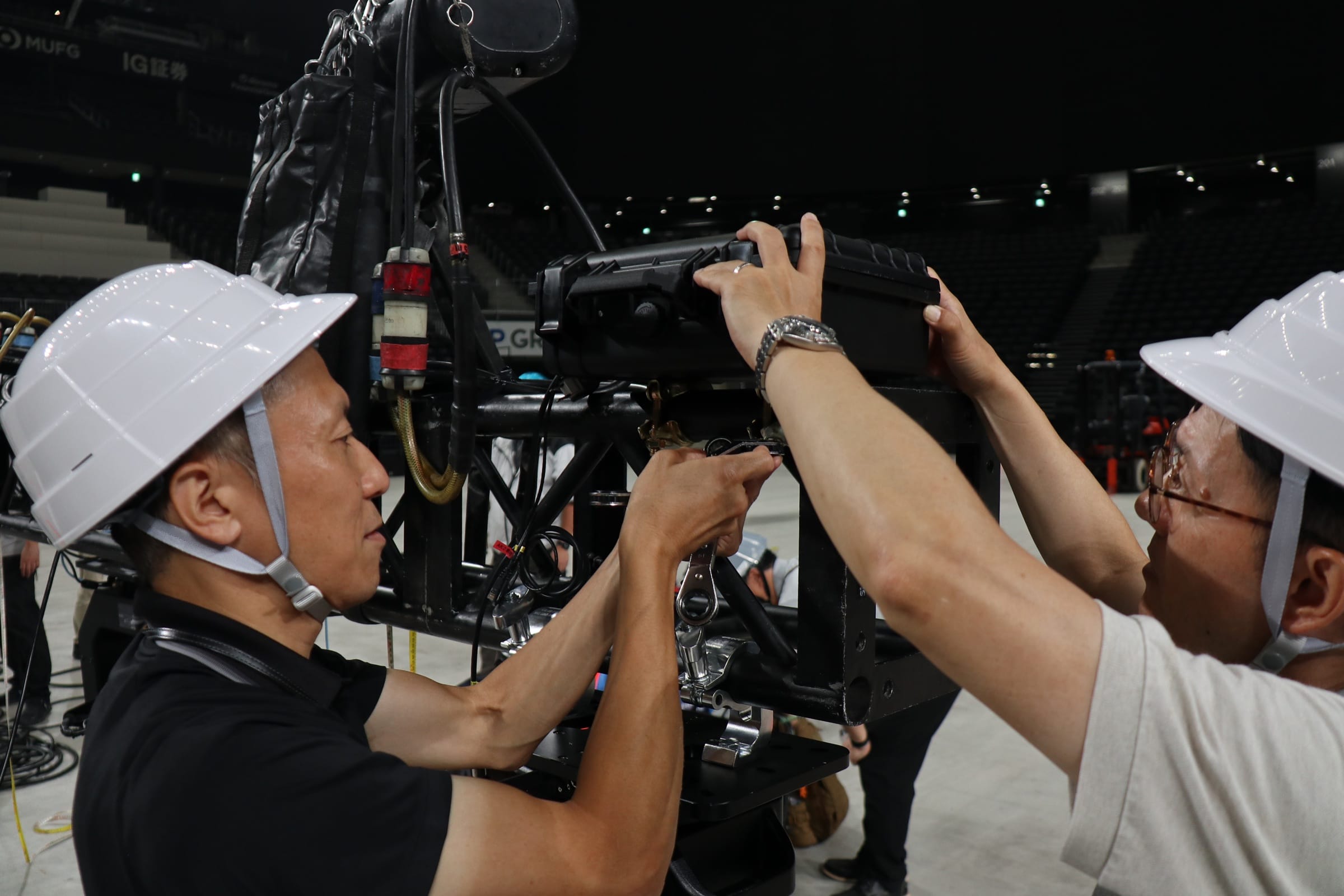A Canon employee in a helmet installing camera equipment on the ceiling