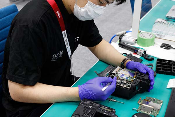 Technicians at work maintaining and repairing cameras and lenses