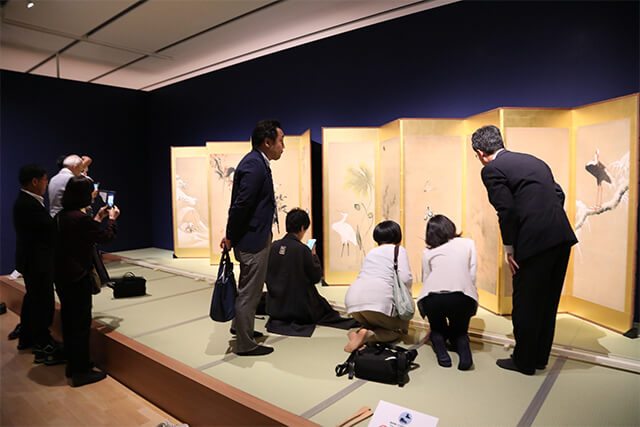 Atendees admire a facsimile in a traditional setting