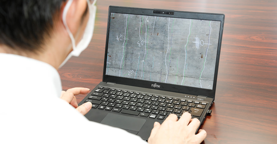 技術者がパソコンを使ってAIによる変状検知結果を確認している画像