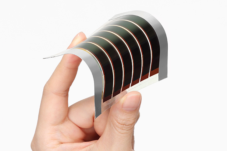 ペロブスカイト太陽電池を片手で折り曲げて、薄さ、軽さ、曲がる点を伝える画像